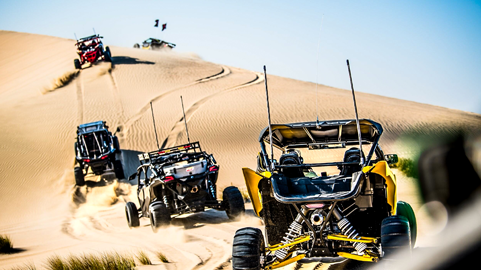 Group of side-by-sides driving in the sand dunes